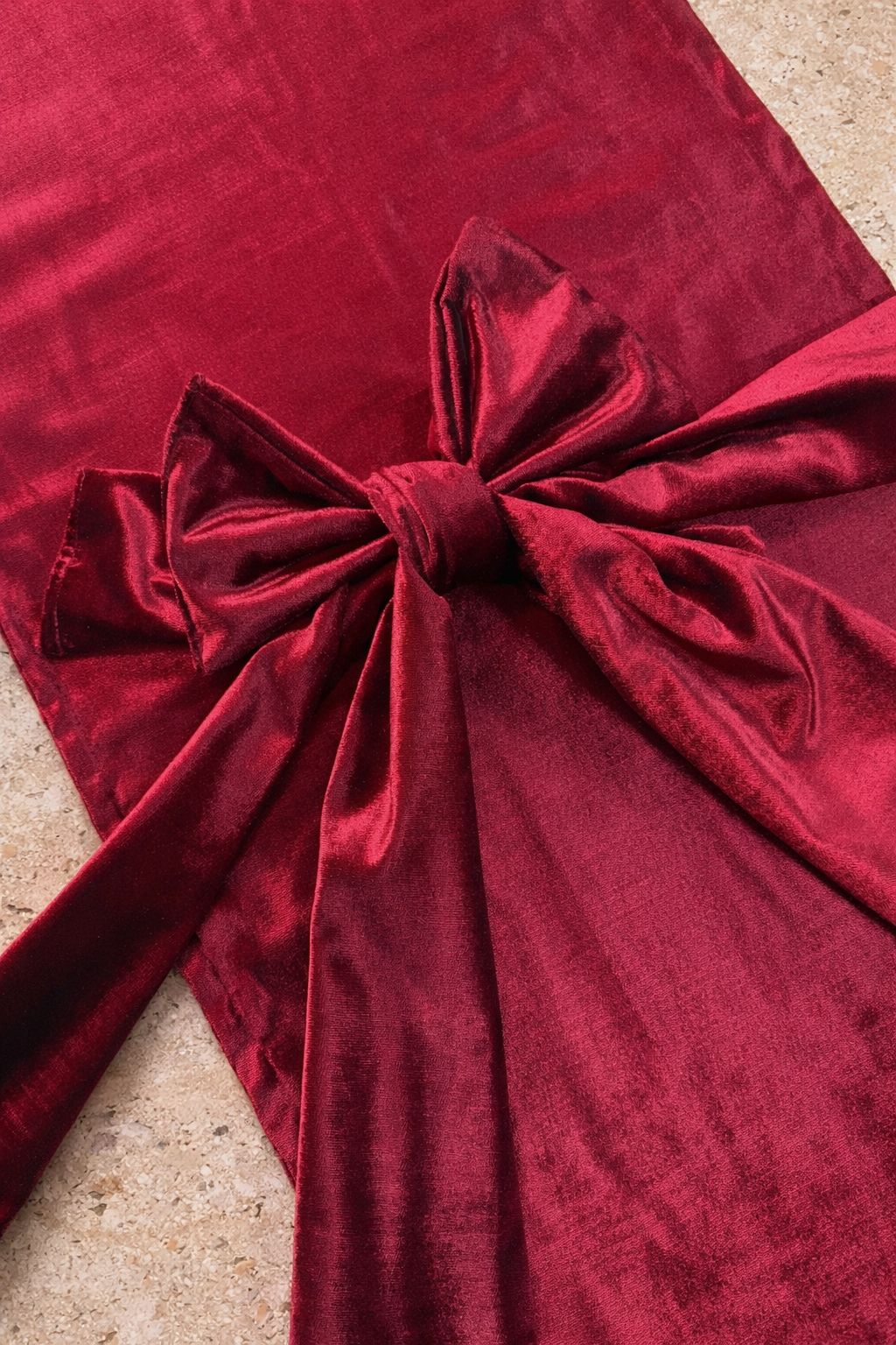 Kırmızı premium kadife runner, el formunda büyük fiyonk detayı. Yumuşak doku, %100 polyester. Özel davet ve yılbaşı sofraları için zarif aksesuar.